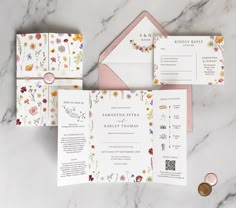 the wedding stationery is laid out on a marble table