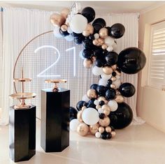 black and white balloons are arranged in the shape of an arch for a new year's eve celebration