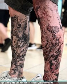 a man with tattoos on his legs and leg is standing in front of other people