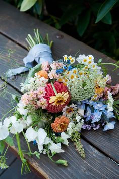 a bouquet of flowers sitting on top of a wooden bench