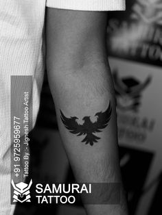 a black and white photo of a man with a tattoo on his arm that has an eagle on it