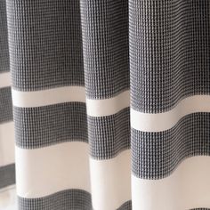 black and white checkered curtains hanging on the side of a window sill in front of a curtain