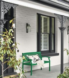 an instagram page with a green bench in front of a white house and black shutters