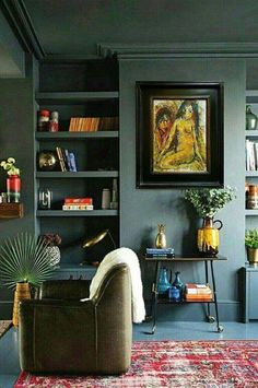 a living room filled with furniture and bookshelves next to a painting on the wall