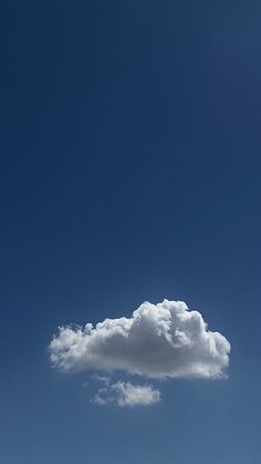 an airplane flying in the sky with a cloud above it