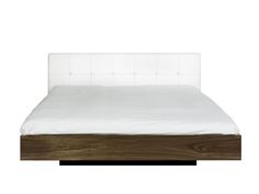 a bed with white sheets and wooden headboard