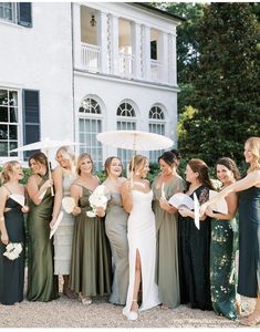 a group of women standing next to each other in front of a building holding umbrellas