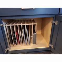 a kitchen cabinet filled with lots of different types of knives and pans in it