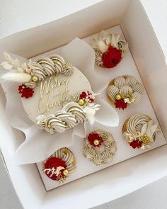 a white box filled with cupcakes covered in frosted icing and flowers