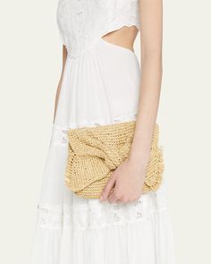 Anya Hindmarch clutch bag in straw with bow fringe accent     Flap top with magnetic closure     Interior, one card slot     Approx. 7.5"H x 11.4"W x 2"D    Imported Elegant Straw Bag For Day Out, Chic Natural Color Straw Clutch Bag, Chic Straw Clutch With Braided Handles, Chic Natural Clutch For Spring, Elegant Woven Clutch For Vacation, Chic Beige Woven Clutch, Beige Straw Clutch For Evening, Chic Summer Clutch With Braided Handles, Chic Vacation Clutch With Braided Handles