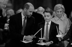 a man and boy holding candles in front of other people