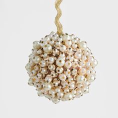 an ornament with pearls hanging from a rope