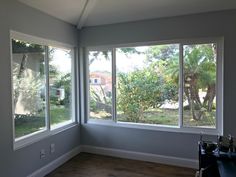 an empty room with three large windows in it