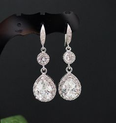 pair of earrings with white stones on black background