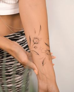 a woman's arm with a flower tattoo on it