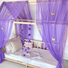 a purple canopy bed with butterflies on it