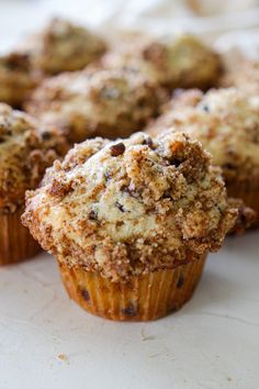 several muffins with crumbs on them sitting on a white counter top