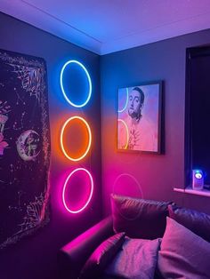 a living room filled with furniture and neon lights on the wall behind it is a couch