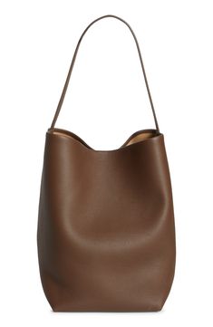 A softly structured silhouette defines this timeless tote crafted from supple calfskin leather. Open top Shoulder strap Leather lining Leather Made in Italy Designer Handbags North South, Open Top, Dream Wardrobe, Leather Tote, Designer Handbags, The Row, Calf Skin, Leather Straps, Shoulder Strap