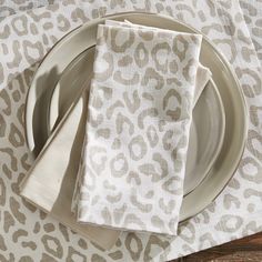 the napkins are sitting on top of the plate and next to the place setting