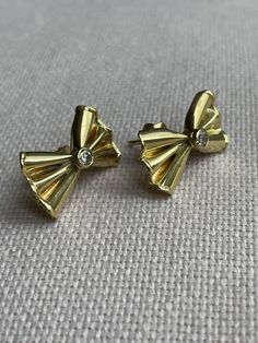 A lovely pair of vintage bow shaped earrings. These cute pair of bows with a delicate diamond detail would match almost every outfit! While bow shaped earrings are not very easy to find, rings designed as a bow marked the typical '50's jewellery. This pair was made in 18 karat yellow gold and is featuring two old brilliant cut diamonds of 0,08 ct. in total, ca. G-H, ca. VS. The gold has a wonderful warm yellow tone. Provenance: Italy. Measurements: 15 x 9 mm. Gross weight: mint condition, hardly Tiny Gold Studs, Mountain Earrings, Silver Bar Earrings, Mint Earrings, Laser Engraved Leather, Aqua Earrings, Yellow Tone, Surgical Steel Earrings, Rose Gold Studs