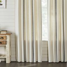 the curtains in this room are lined with black and white striped draperies, along with a wooden table