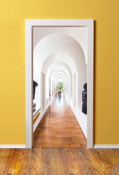 an open door leading to a hallway with yellow walls and wooden floors in the center