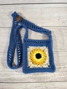 a blue crocheted bag with a yellow sunflower on it