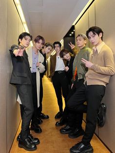 a group of young men standing next to each other on a hallway between two walls