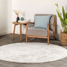 a chair and table in a room with white walls, wood floors and wooden flooring