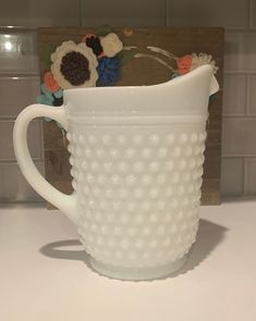 a white glass pitcher sitting on top of a counter