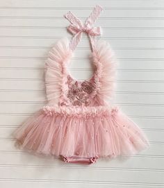 This listing is for the Augusta Romper. It is made with a light pink velvet fabric and pearl tulle mesh. The front is embellished with a floral appliqué . The romper has sewn in bloomers. It also has frilly straps and an open back.  All of my items are made in a smoke free home and will be mailed in a box to ensure safety of the romper.  Size Chart                                                Measured in Inches                             Newborn/Preemie:     Chest - 15.5 Waist - 16 Hips - 16 Pink Lace Tutu Dress For Baptism, Fitted Glitter Tulle Tutu Dress For Summer, Embellished Tulle Tutu Dress For Pageants, Embellished Tulle Tutu Dress For Pageant, Fitted Lace Tutu Dress With Floral Applique, Sleeveless Embellished Tulle Tutu Dress, Pink Whimsical Tutu Dress With Floral Applique, Whimsical Pink Tutu Dress With Floral Applique, Pink Princess Tutu Dress With Floral Applique