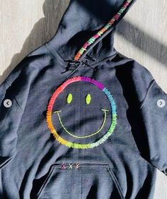 Black adult unisex size hoodie hand embroidered smiley face with neon threads Trendy Custom Embroidery Sweatshirt For Streetwear, Trendy Streetwear Sweatshirt With Custom Embroidery, Trendy Hoodie With Embroidered Logo, Embroidered Hoodie With Relaxed Fit For Streetwear, Embroidered Relaxed Fit Hoodie For Streetwear, Fall Smiley Face Sweatshirt For Streetwear, Cotton Smiley Face Sweatshirt For Streetwear, Hoodie Stitching Ideas, Painting Sweatshirts