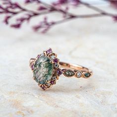 a close up of a ring on a table with flowers in the background and leaves