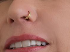 a woman's nose with a gold nose piercing