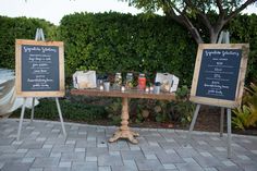 a table with two chalkboards and drinks on it