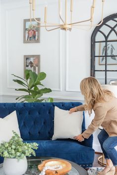 a woman is sitting on a blue couch