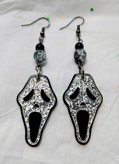 Black color dangle earrings decorated with various beads, and a pendant featuring the famous Scream villain Ghostface's mask embedded with glitter. Size per earring: W- 1 in H- 4 in Please note that colors may vary from pictures due to lighting when pictures were taken, thank you. Horror Scream, Scream Movie, Etsy Earrings Dangle, Scream, Black Color, Dangle Drop Earrings, Dangle Earrings, Handmade Items, Etsy Gift Card