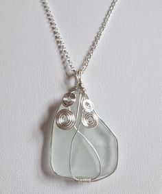 Real and natural white sea glass from the Tyrrhenian Sea, set with silver-plated jewelry wire. Optionally available with or without the 45 centimeter long 925 sterling silver chain. This white sea glass pendant has a particularly unusual shape and looks very interesting as a necklace pendant. It is not completely even on the back, which emphasizes its unique character in a positive way (see picture of back). It is relatively large: almost 3 cm long and about 2.5 cm wide without the setting and w Wire Wrapped Silver Recycled Glass Jewelry, Silver Wire-wrapped Necklace With Recycled Glass, Wire Wrapped Silver Jewelry With Recycled Glass, Silver Wire Wrapped Necklace With Recycled Glass, White Recycled Glass Jewelry Gift, Handmade White Sea Glass Jewelry, White Recycled Glass Jewelry For The Beach, Silver Sea Glass Necklace With Wire Wrapped Detail, Wire Wrapped Silver Sea Glass Necklaces