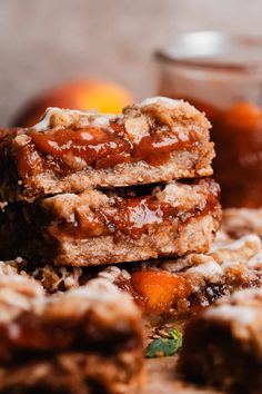 three pieces of dessert sitting on top of each other next to oranges and sauce