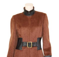 "This vintage alpaca blend coat is simply stunning. It's cut from a luxurious burnt sienna alpaca & wool blend fabric and has black leather trim. The coat also features a flattering tailored fit-n-flare silhouette and mod style elements for a true head turner. Collar can be worn zipped up as a turtleneck, or slightly unzipped for a more casual look. Coat is fully lined, has attached belt closure with brass hardware, and zips in front with a hidden brass zipper. Best fits size xs, small, or m Wool Coat For Evening Wear In Fall, Evening Wool Coat For Fall, Fitted Luxury Brown Outerwear, Luxury Fitted Brown Outerwear, Fitted Wool Coat For Winter Evenings, Fitted Brown Wool Coat For Fall, Vintage Fitted Wool Coat For Winter, Elegant Fitted Brown Wool Coat, Elegant Brown Outerwear For Evening