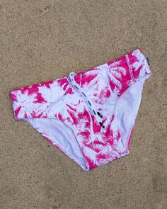 PINK PALMS mens swim brief is a high-performance swim brief with eco-friendly features--it's made of recycled polyester (86% recycled polyester, 14% lycra) with microfiber technology, guaranteeing fast drying and color resistance. Plus, it offers effective UV protection, so you can swim with peace of mind. A smart and stylish choice for your next pool party or beach outing. SIZINGOur suits are designed with specific materials and construction methods that may cause them to fit slightly smaller t Pink Swim Trunks For Beachwear, Pink Swim Trunks For Water Sports, Pink Swimwear For Water Sports And Beach Season, Sporty Pink Swim Trunks For Pool, Pink Beachwear Swim Trunks For Sports, Pink Stretch Swim Trunks For Swimming, Pink Stretch Swim Trunks, Pink Fitted Swim Trunks For Sports, Pink Moisture-wicking Swimwear For Poolside