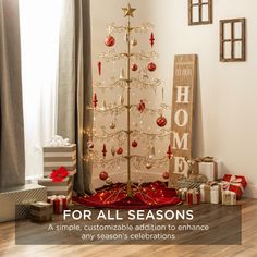 a white christmas tree with red and gold ornaments on it in front of a window