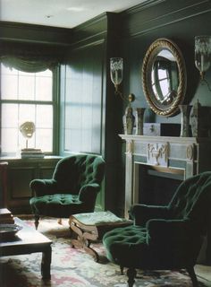 a living room filled with furniture and a fire place in front of a mirror on the wall