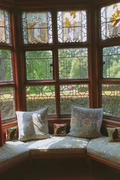 a corner couch sitting in front of a window with lots of stained glass windows behind it