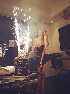 a woman standing in front of a chandelier with sparkles on top of it