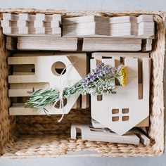 a bunch of flowers sitting inside of a wooden box with some sort of house on it