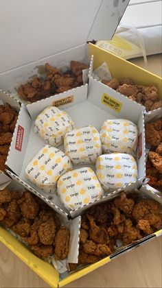 an open box filled with cookies sitting on top of a wooden table next to other boxes