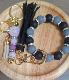 a wooden tray topped with bracelets and key chains