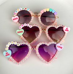 four heart shaped sunglasses with the word love spelled on them